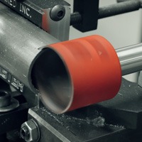 En bit rött material som bearbetas på en Hålsåg MK Morse Advanced Edge 14-168mm.