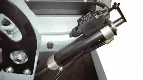 Närbild av en svart industriell pneumatisk cylinder monterad på en FEMI Metallbandsåg 2200 DAXL ½ Automatisk hydraulisk 230V maskin.