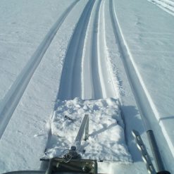 Spårdragare Spår-Juha spår skär genom en snöig yta, sett ur förarens perspektiv.