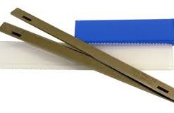 Två Hyvelstål HSS 260 x 3,0 x 18mm med 2 spår liggande på en blåvit plastlåda.